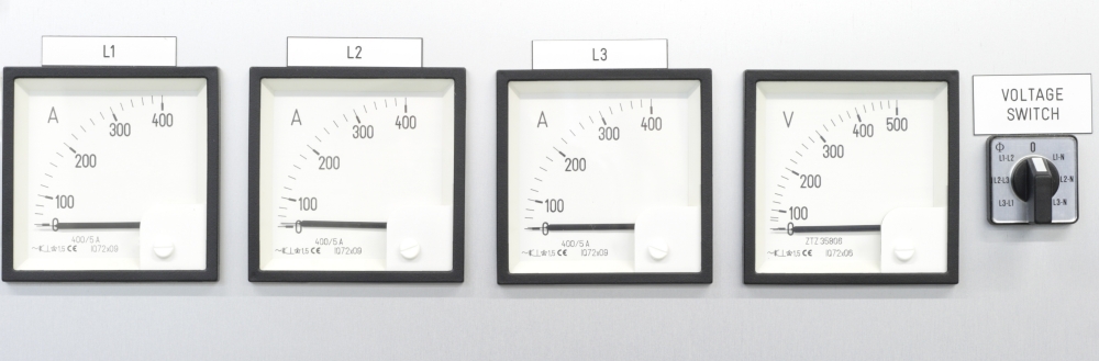 Four analog meters displaying current and voltage readings, labeled L1, L2, L3, and a voltage meter, along with a voltage switch.