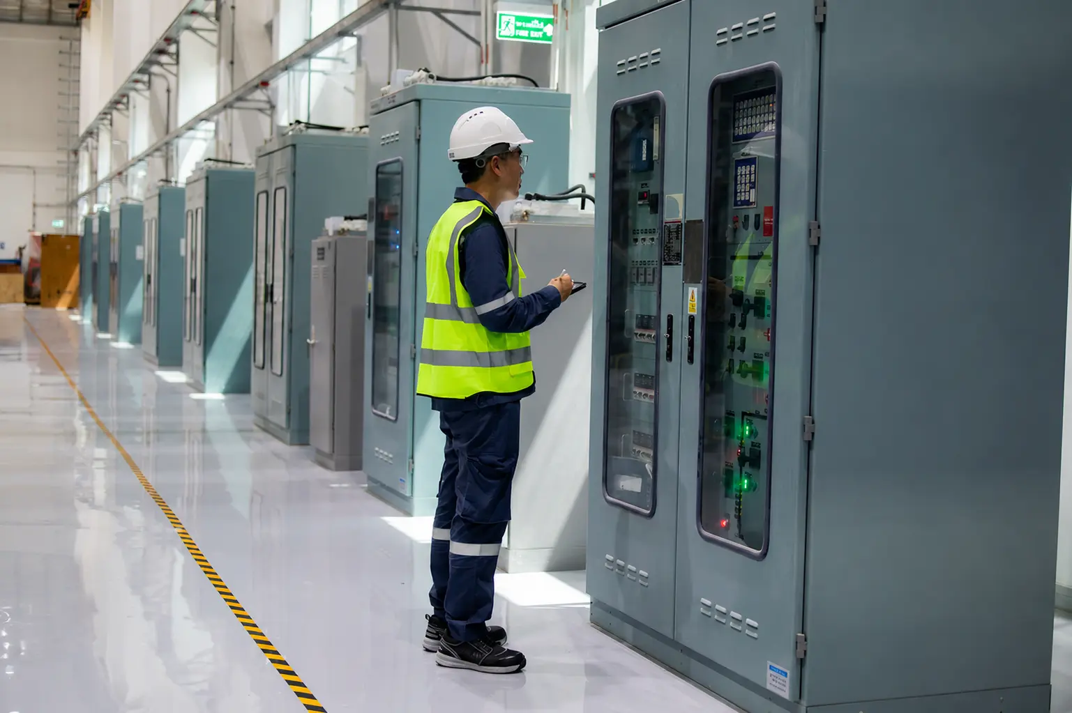 Engineer working on industrial electrical control cabinets