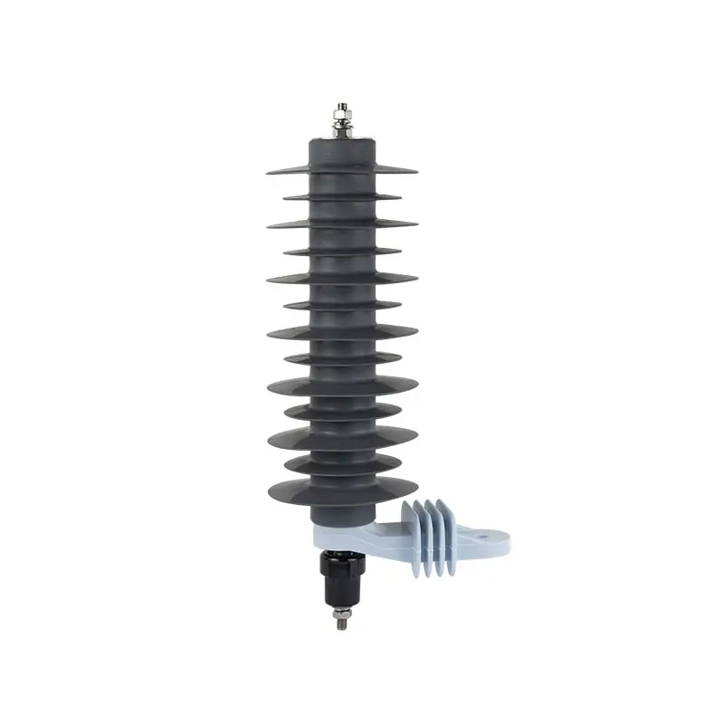 The image shows a surge arrester, an electrical device used to protect electrical equipment from voltage spikes. The arrester has a vertical, cylindrical shape with multiple gray, circular flanges stacked along its length, diminishing in size towards the top. The top of the arrester has a metal cap with a connection point, possibly for grounding. There's a white insulating bracket with a winding, indicating its mount to a structure, and at the bottom, there is a black attachment, likely for connecting to a power line. The background is plain white, highlighting the surge arrester.